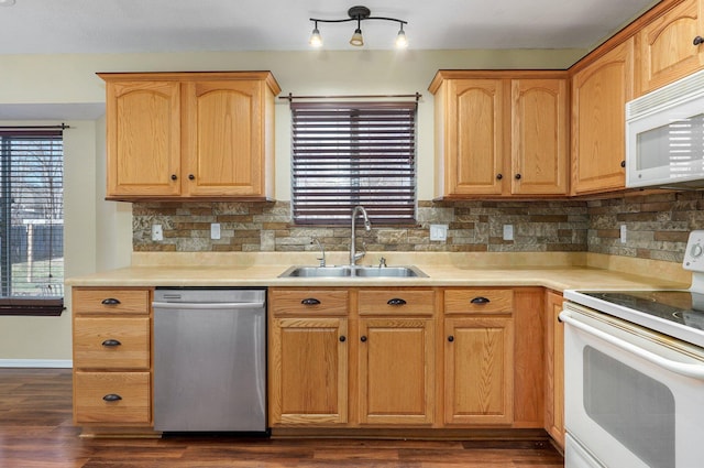 kitchen with dark hardwood / wood-style flooring, decorative backsplash, sink, and white appliances