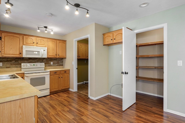 kitchen featuring decorative backsplash, dark hardwood / wood-style floors, white appliances, and sink