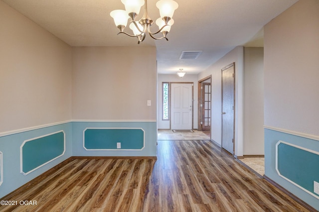 foyer entrance with wood-type flooring and an inviting chandelier