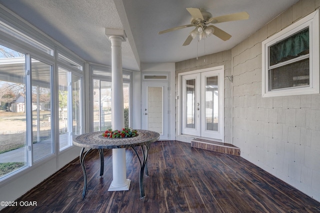 unfurnished sunroom featuring ornate columns, ceiling fan, and french doors