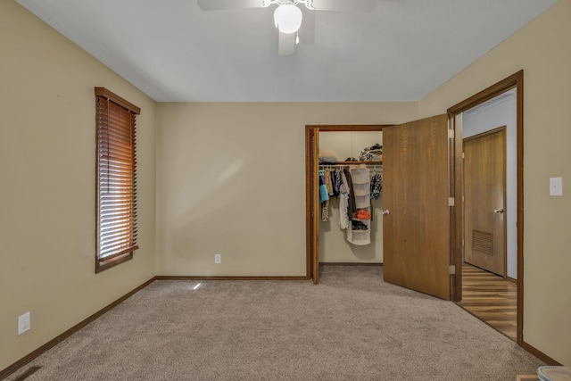 unfurnished bedroom featuring carpet floors, a closet, a spacious closet, and ceiling fan