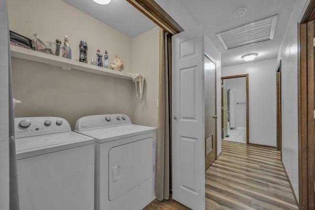 laundry room with light wood-type flooring and separate washer and dryer