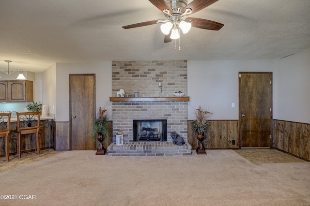 unfurnished living room with a textured ceiling, light colored carpet, and a brick fireplace