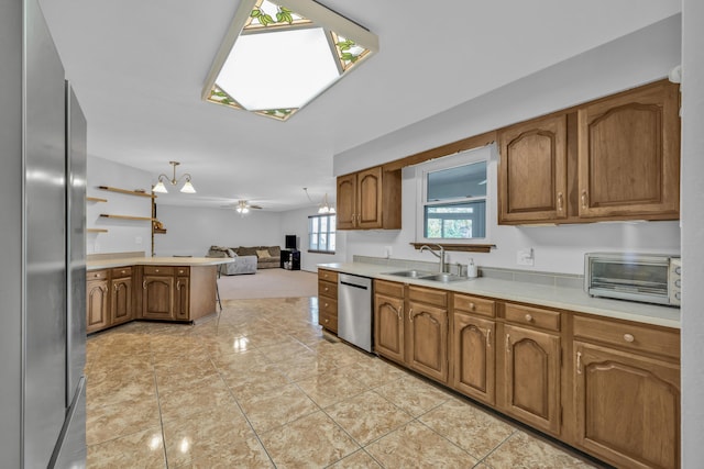 kitchen with ceiling fan, dishwasher, sink, hanging light fixtures, and kitchen peninsula