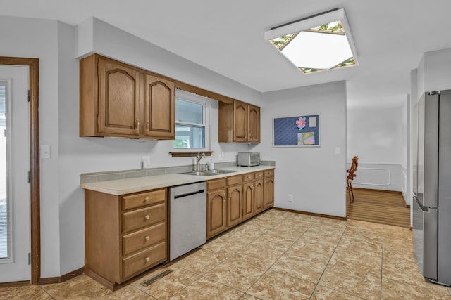 kitchen featuring sink, light tile patterned floors, and stainless steel appliances