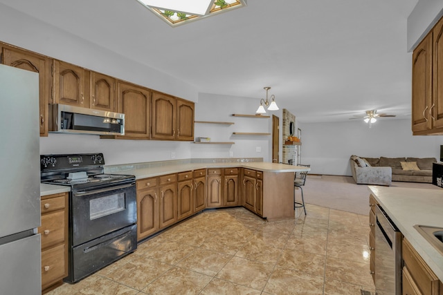 kitchen featuring a kitchen breakfast bar, ceiling fan with notable chandelier, decorative light fixtures, kitchen peninsula, and stainless steel appliances