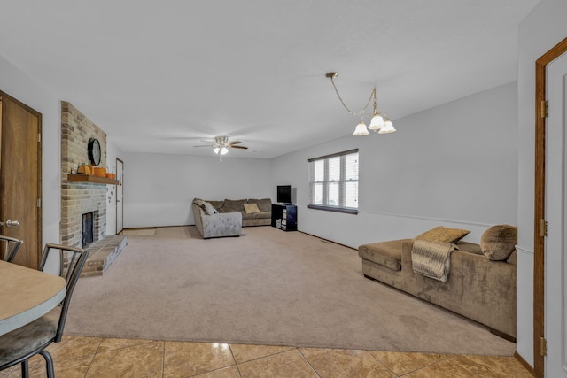 carpeted living room with ceiling fan with notable chandelier and a fireplace