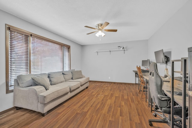 living room featuring ceiling fan and hardwood / wood-style flooring