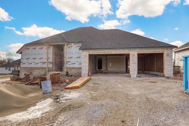 property under construction featuring brick siding and roof with shingles