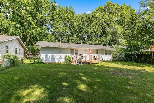 back of house with a deck and a yard