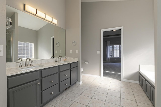 bathroom with tile patterned floors, vanity, a bath, and toilet