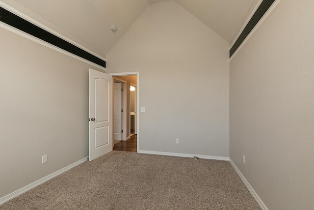 carpeted empty room featuring high vaulted ceiling