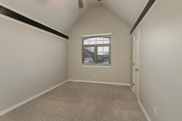 carpeted empty room featuring vaulted ceiling and ceiling fan