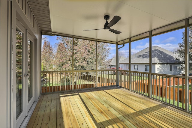 unfurnished sunroom with ceiling fan