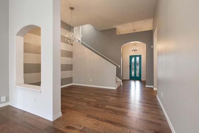 foyer entrance with dark hardwood / wood-style floors and a chandelier