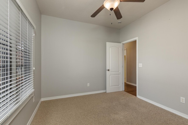 empty room with ceiling fan and carpet floors