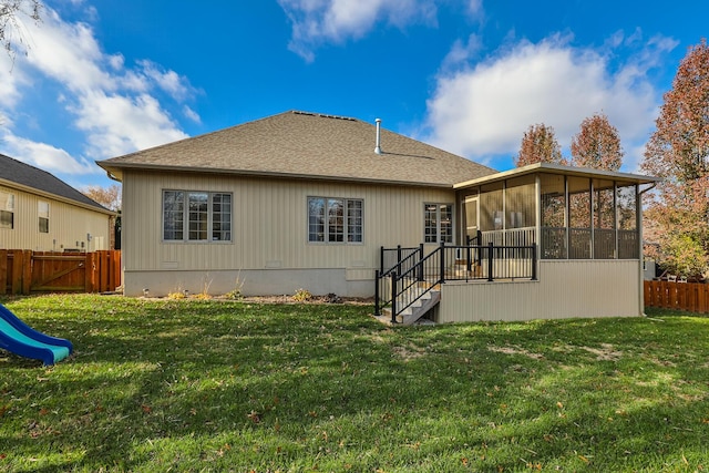 rear view of property featuring a lawn and a sunroom