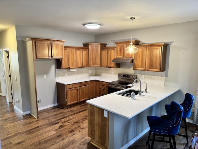 kitchen with pendant lighting, electric range, tasteful backsplash, and sink