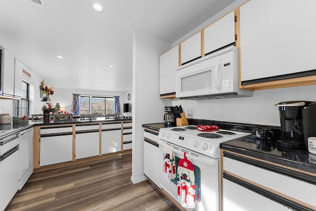 kitchen featuring white appliances, dark hardwood / wood-style floors, and white cabinetry