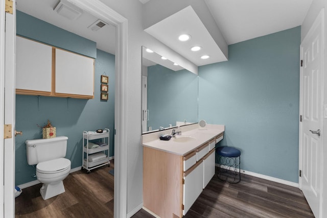 bathroom with hardwood / wood-style floors, vanity, and toilet