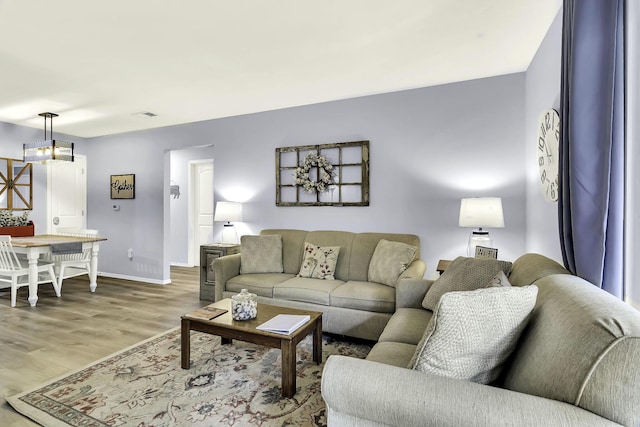 living room with hardwood / wood-style floors and a notable chandelier