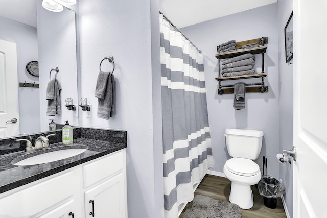 bathroom with toilet, vanity, and hardwood / wood-style flooring