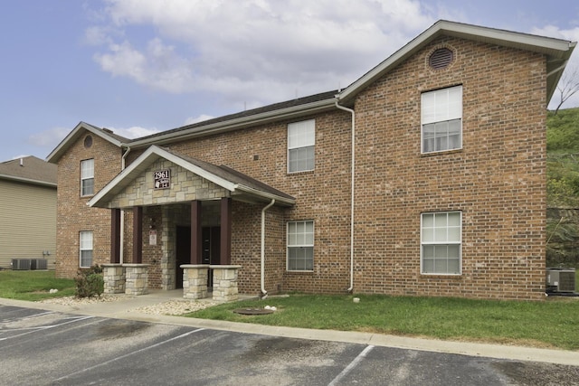 view of front of property featuring a front yard and central air condition unit