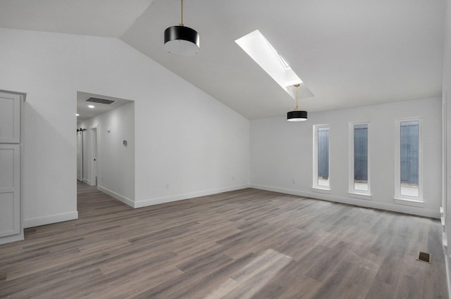 spare room with hardwood / wood-style floors and lofted ceiling with skylight