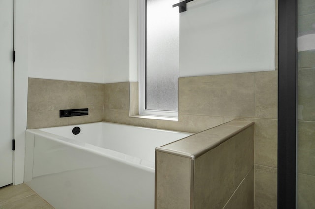 bathroom with tile patterned flooring and a bath