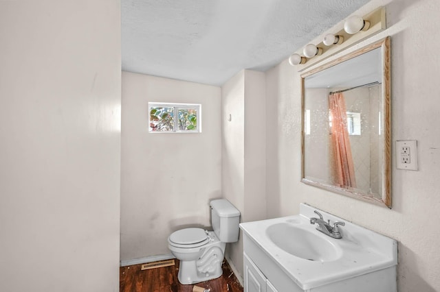 bathroom featuring hardwood / wood-style floors, vanity, toilet, and walk in shower