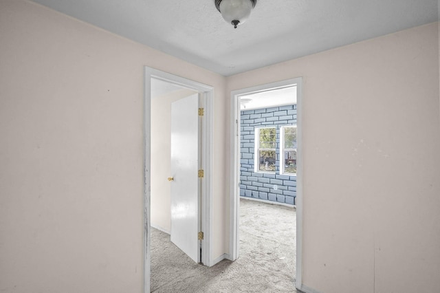 corridor featuring light colored carpet