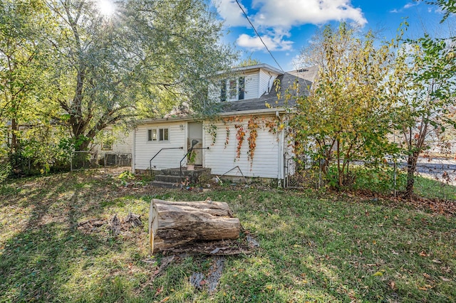 rear view of house featuring a yard