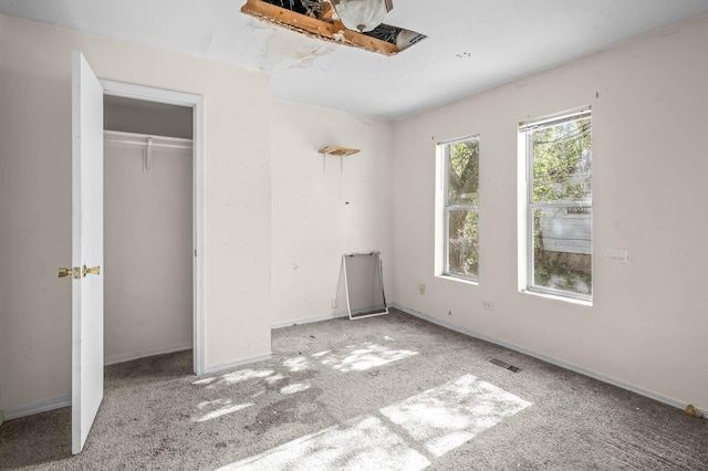 unfurnished bedroom with light carpet and a closet