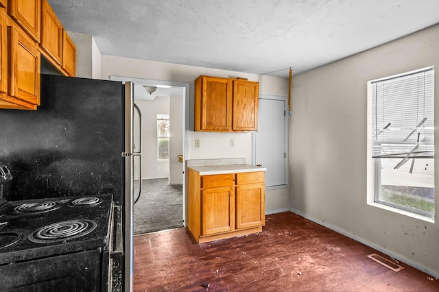 kitchen featuring black electric range, a textured ceiling, and dark hardwood / wood-style floors