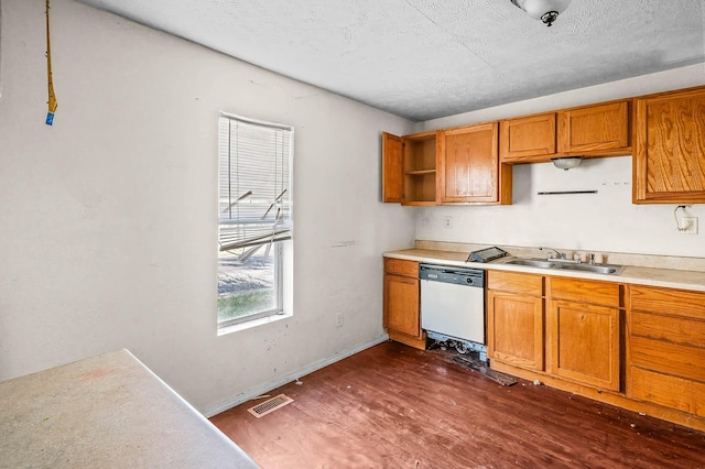 kitchen with a textured ceiling, dishwasher, dark hardwood / wood-style flooring, and sink