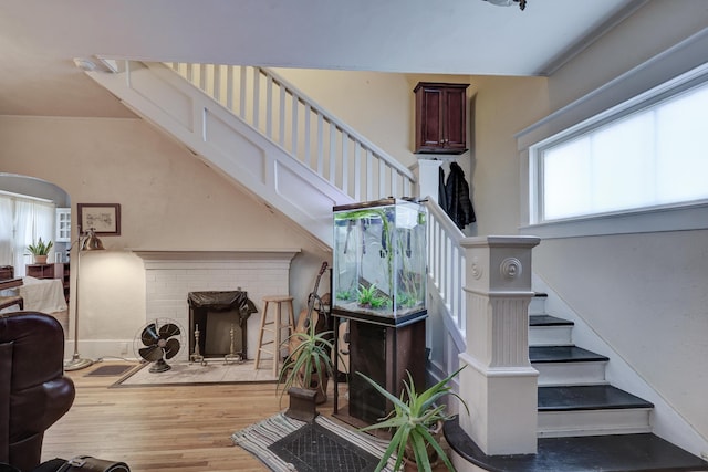 staircase with hardwood / wood-style floors and a wood stove