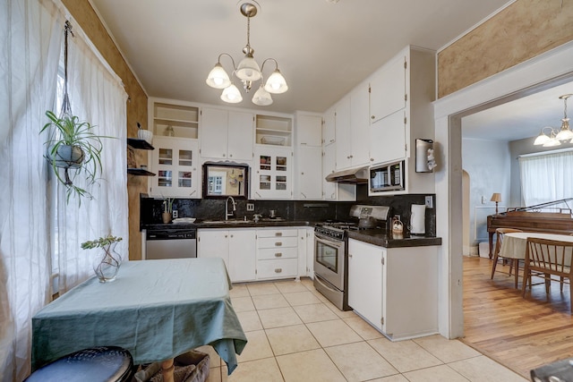 kitchen with decorative light fixtures, appliances with stainless steel finishes, a notable chandelier, light tile patterned flooring, and white cabinetry