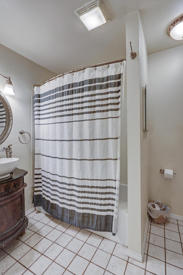 bathroom featuring tile patterned flooring, vanity, and shower / bath combination with curtain