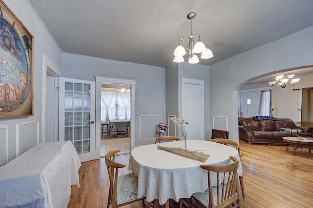 dining area with light hardwood / wood-style flooring and an inviting chandelier