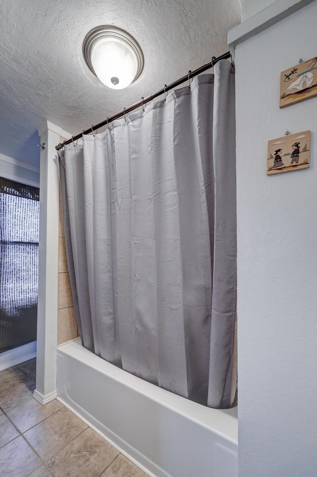 bathroom featuring tile patterned flooring, a textured ceiling, and shower / tub combo with curtain