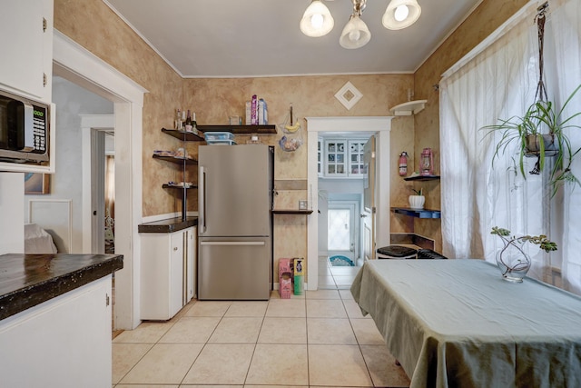 kitchen featuring white cabinetry, light tile patterned floors, a notable chandelier, and appliances with stainless steel finishes