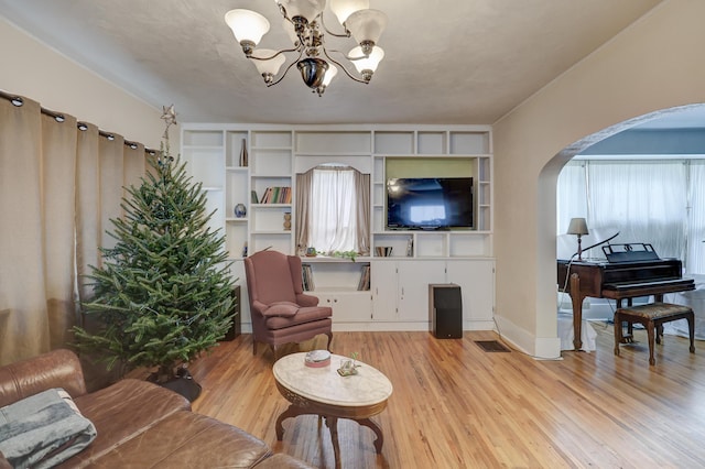 living room featuring light wood-type flooring and a notable chandelier