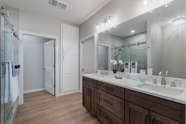 bathroom with vanity, wood-type flooring, and an enclosed shower