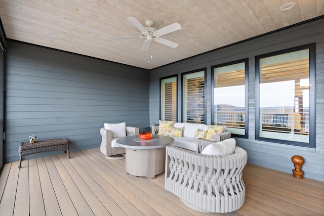 wooden terrace with ceiling fan and an outdoor living space