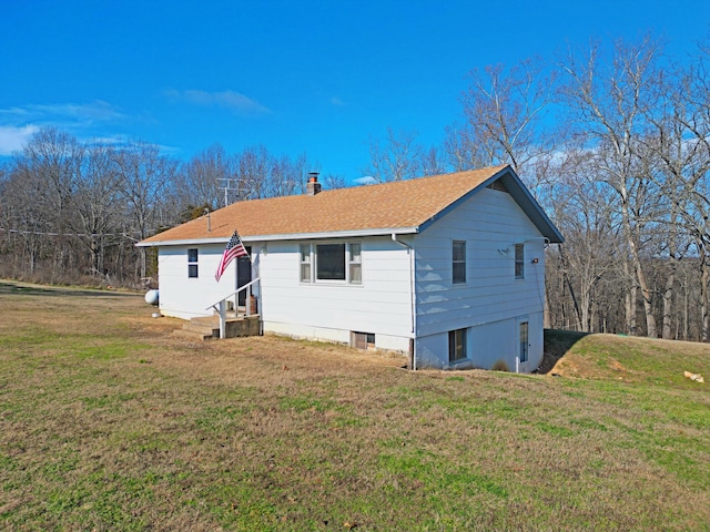 rear view of property featuring a yard