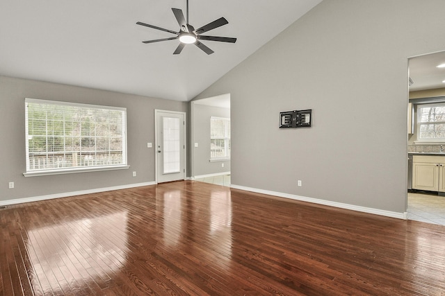 unfurnished living room featuring ceiling fan, light wood-type flooring, and high vaulted ceiling