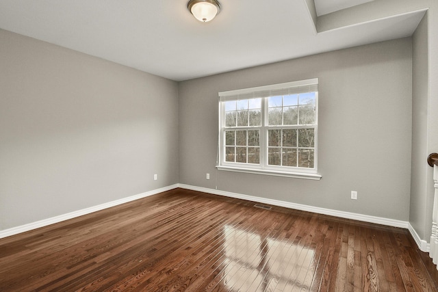 empty room with dark hardwood / wood-style flooring