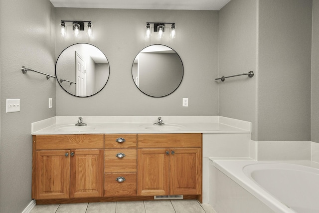 bathroom with tile patterned floors, a bathtub, and vanity