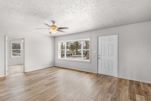 interior space with a textured ceiling and light hardwood / wood-style flooring