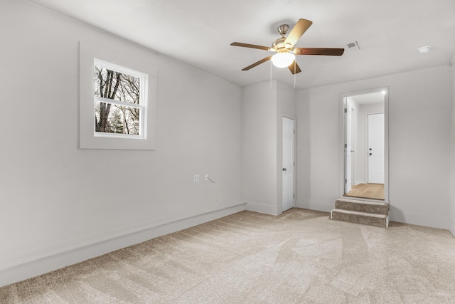 spare room featuring light carpet and ceiling fan